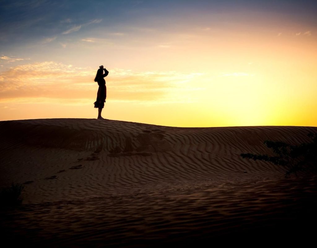 Woman in Los Angeles seeking therapy. Standing on a mountain, black shadow, and sunset