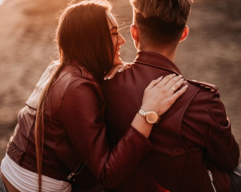 "Two people holding each other in Los Angeles, symbolizing the journey towards secure attachment. Both are wearing brown leather jcakets