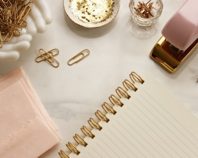 An IFS and trauma therapy office in Los Angeles. Notebook, paperclips, and journal on marble table.