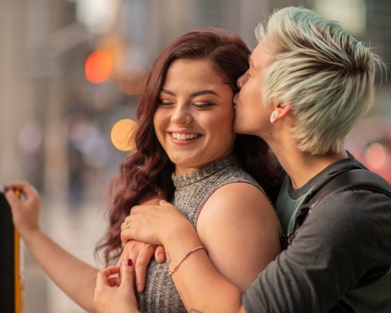 Two women in los angeles hugging and showing affection from attachment therapy in LA. women are smiling and look happy and in love.