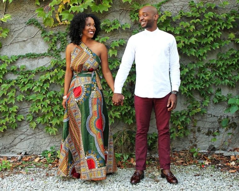 Couple in los angeles standing in front of green leaves. Couple is holding hands, looks happy, and waiting for attachment therapy session.