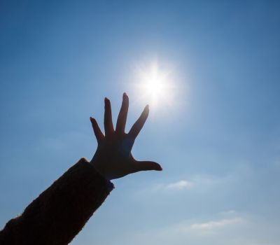 Hand up towards the sky on a sunny los angeles beach