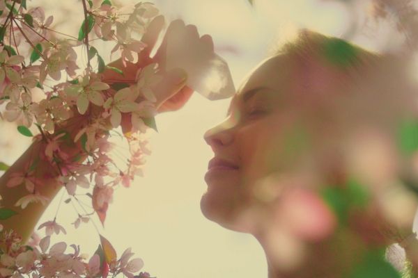 Woman smelling flowers outside in Los Angeles. Woman looks calm and relaxed.