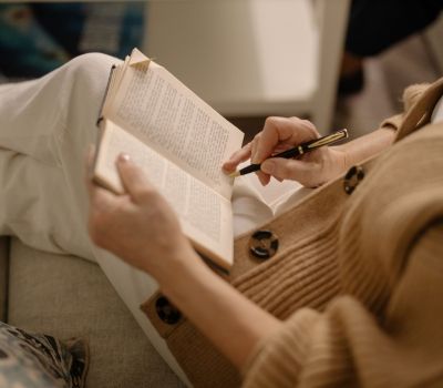 Woman reading in a therapist's office in Los Angeles. Office is calm with beige colors, and woman is reading about somatic therapy and anxiety symptoms.