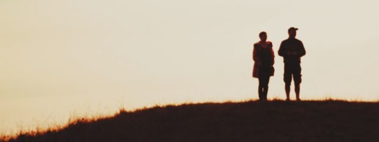 Shadow of a man and woman in a Los Angeles meadow, representing trauma therapy and healing