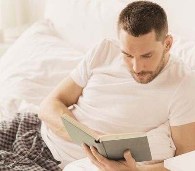 Man deep in thought while reading, symbolizing introspection and healing in somatic therapy