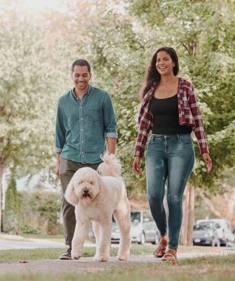 A man and woman walking their dog as part of holistic and somatic therapy in Los Angeles.