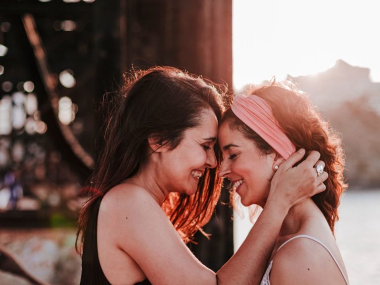 Two women holding each other on a Los Angeles beach, showing their love and affection with each other through attachment therapy in Los Angeles.