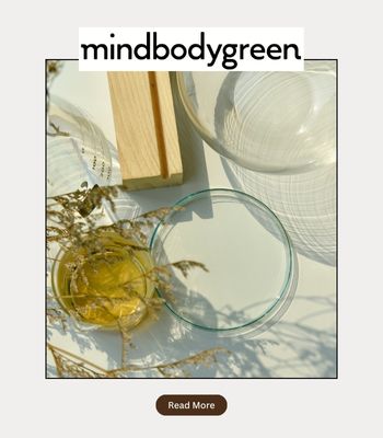 Photo showing a relaxing holistic therapy office with herbs and calming accessories, with the words "Mindbodygreen" on it. Photo says "read here" to get access to Cheryl Groskopf's feature in the magazine, discussing trauma responses, such as fawn response to trauma and how it often masks as people pleasing