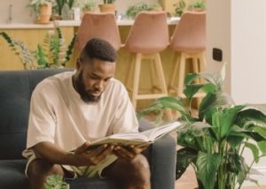 Man reading about somatic therapy in a relaxing home environment setting in Los Angeles