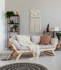 A cozy therapy office set up for holistic anxiety therapy in Los Angeles. Couch has pillows and macrame in background.