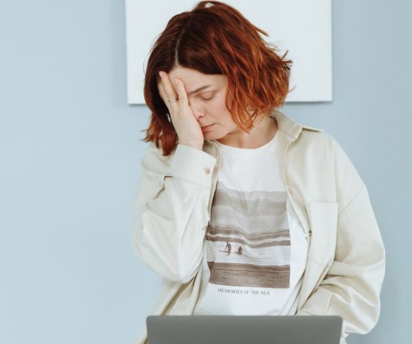 Woman looking frustrated with her laptop during a work session.