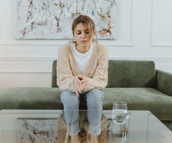 Sad woman on a couch during a somatic therapy session in Los Angeles