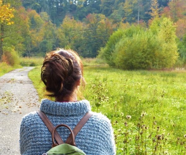 Woman walking along a peaceful nature path, symbolizing grounding and healing in somatic therapy in Los Angeles