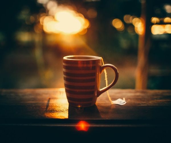 Striped tea mug at sunset, symbolizing relaxation and self-care during trauma therapy in Los Angeles.