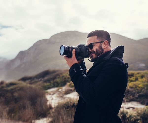 A professional photographer outdoors, symbolizing holistic self-expression, core elements of somatic and trauma therapy in Los Angeles.