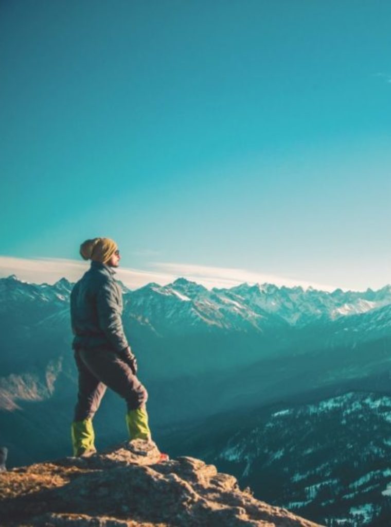 Man in Los Angeles looking off a cliff. Man looks relaxed and rested and healed.