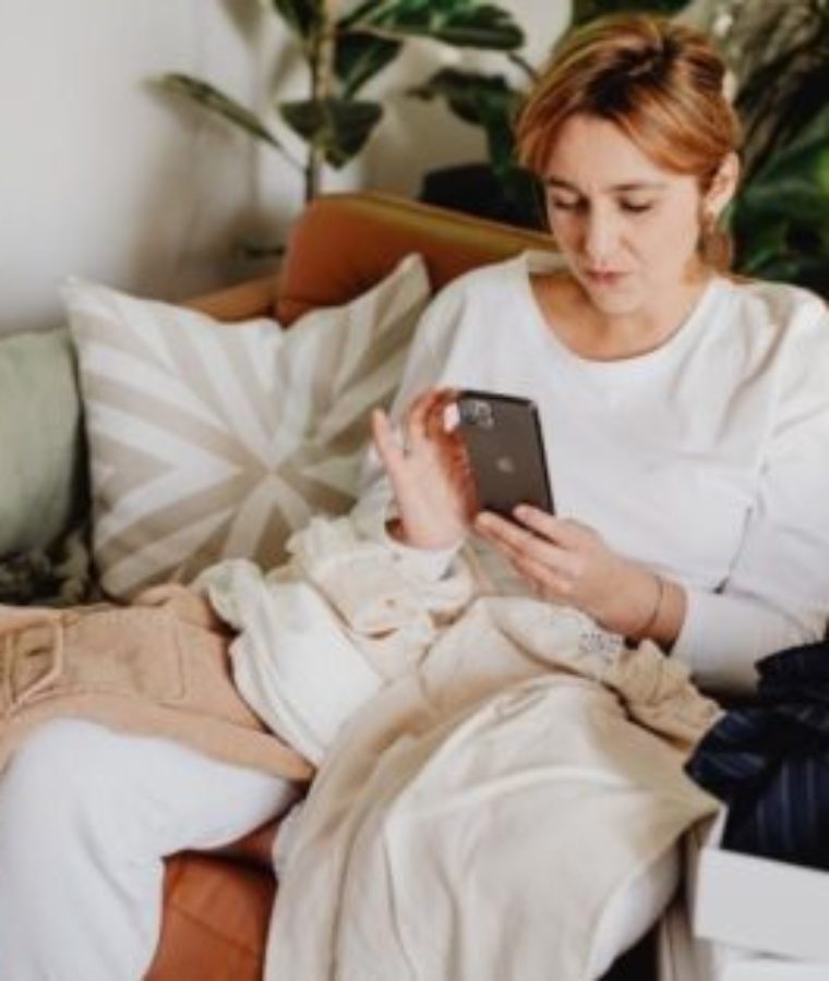 Woman relaxing while getting attachment therapy in Los Angeles. She is on the couch, wearing white clothes, looking relaxed.